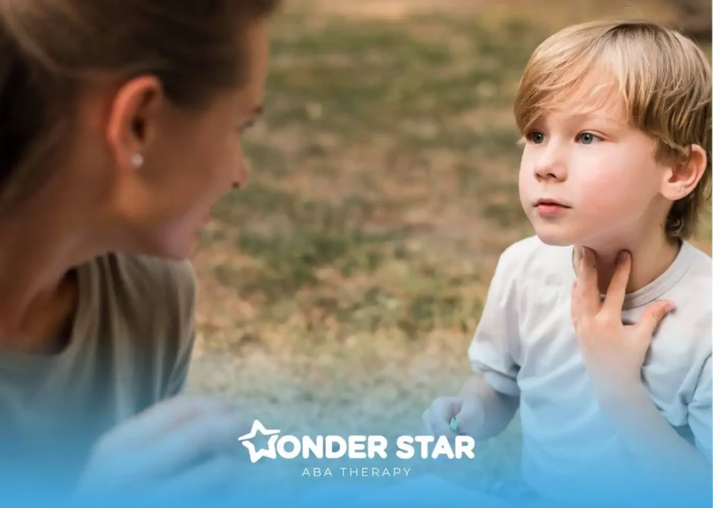 A therapist speaking gently with an autistic child outdoors, encouraging communication while the child touches their throat.