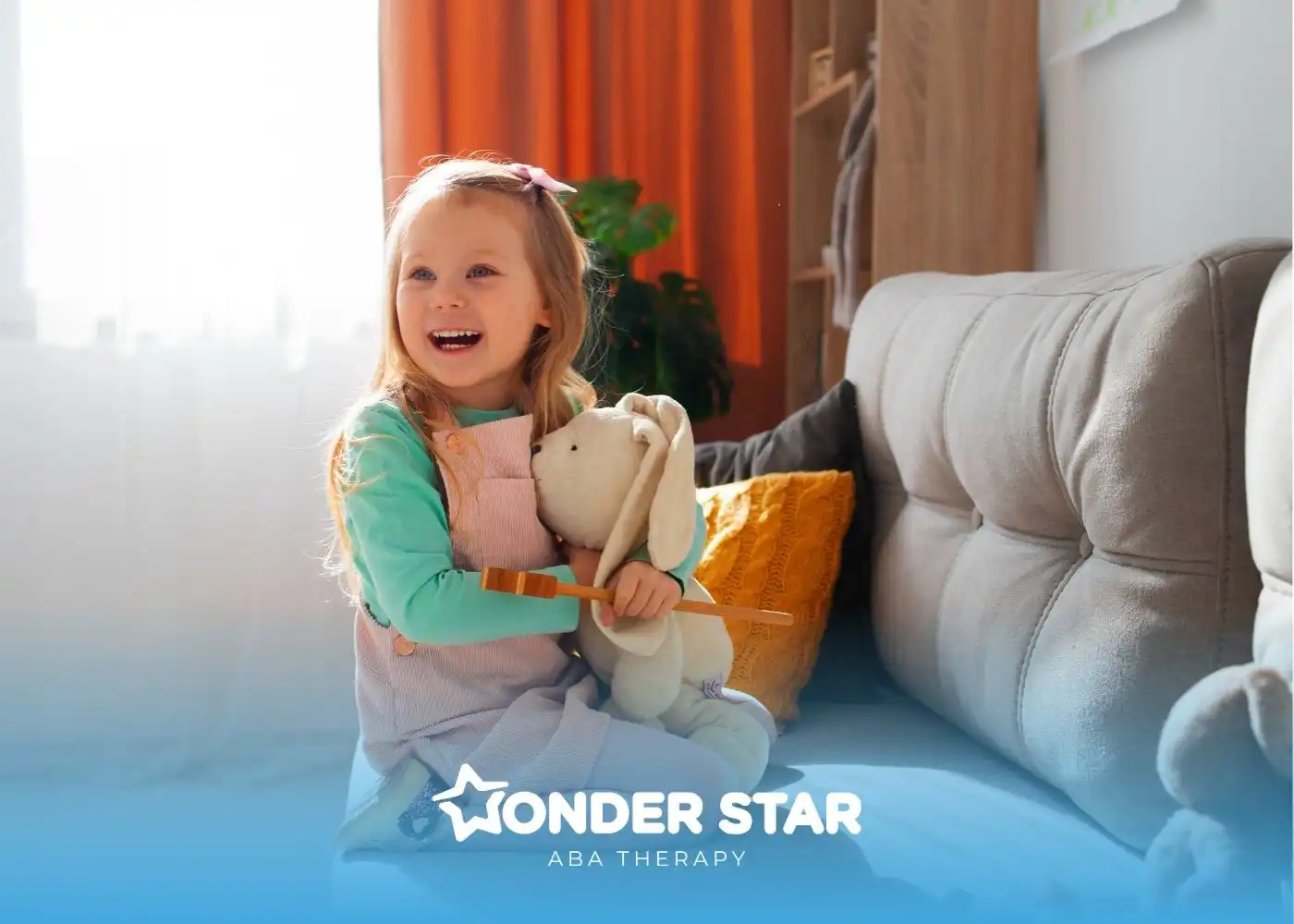 A little girl with autism holding a stuffed animal on the sofa during ABA therapy.