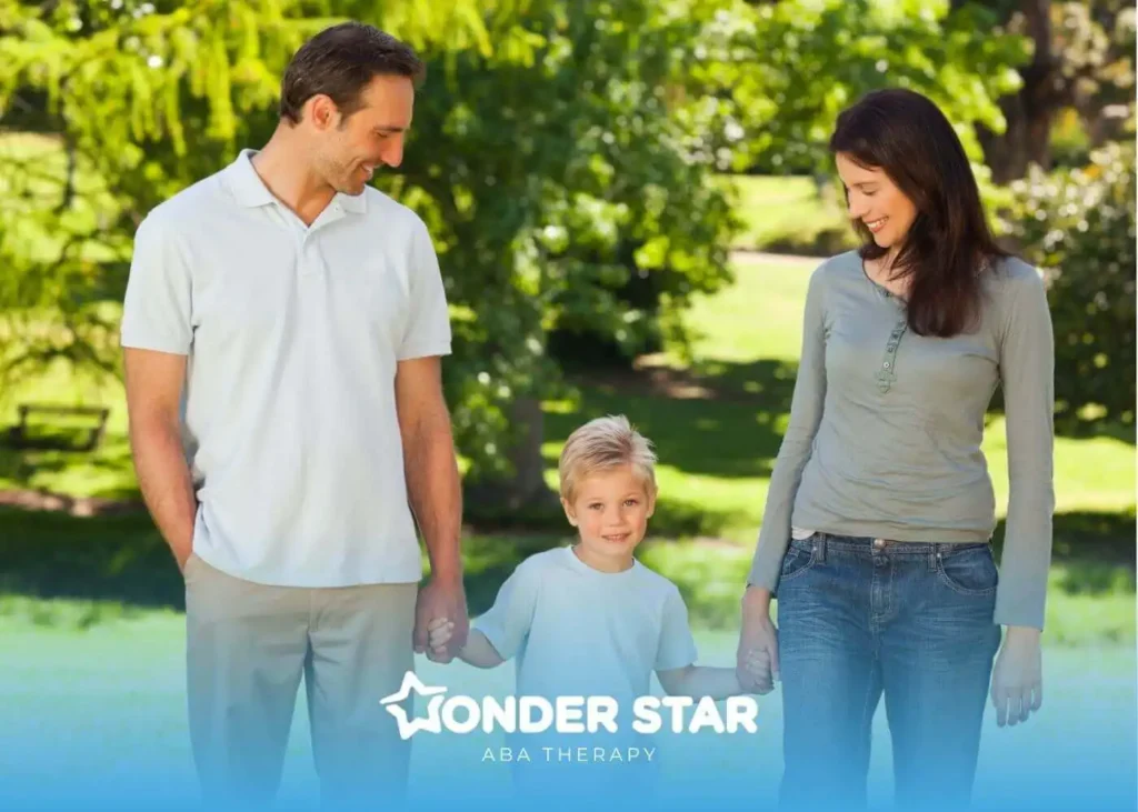 Autistic mother and autistic father walking in a park holding their young son’s hands on a sunny day.