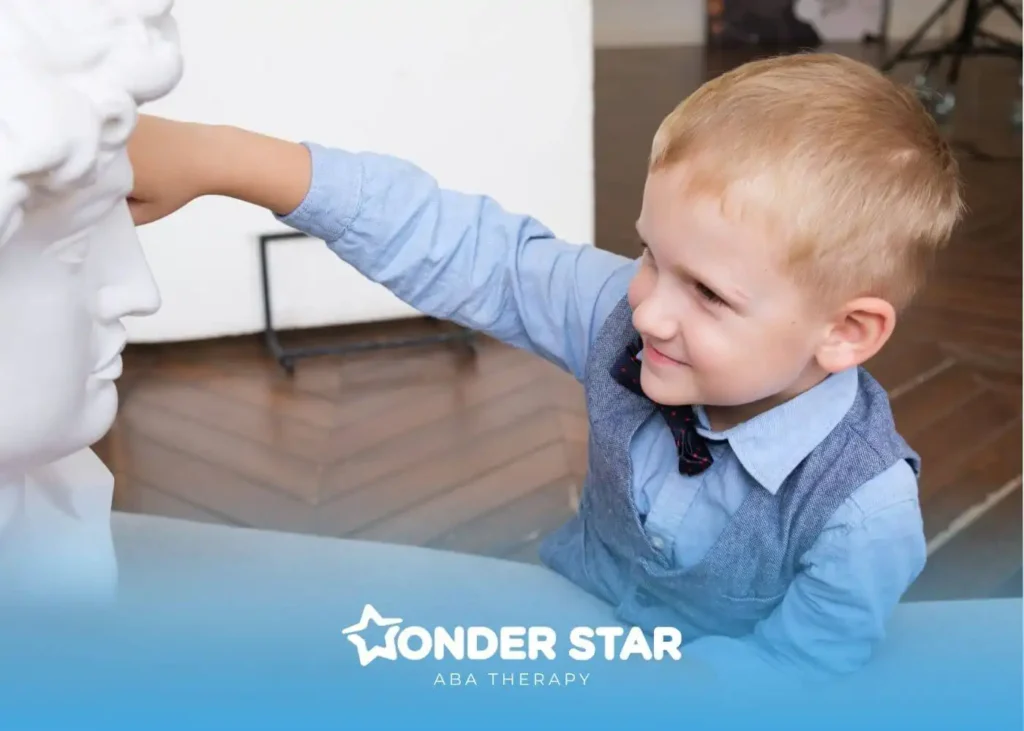 Young autistic boy exploring sensory input by touching sculpture, demonstrating curiosity and early developmental behavior.