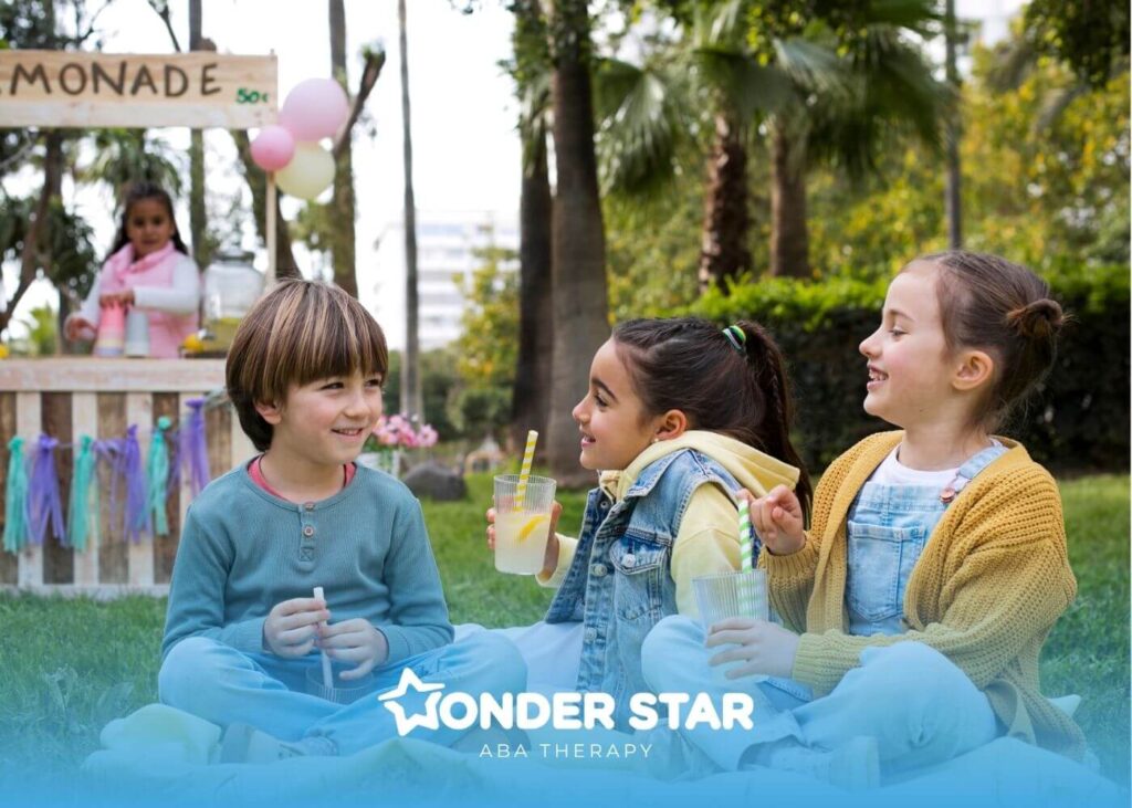 Autistic kids sitting on a picnic blanket outdoors drinking lemonade together, and demonstrating friendship.