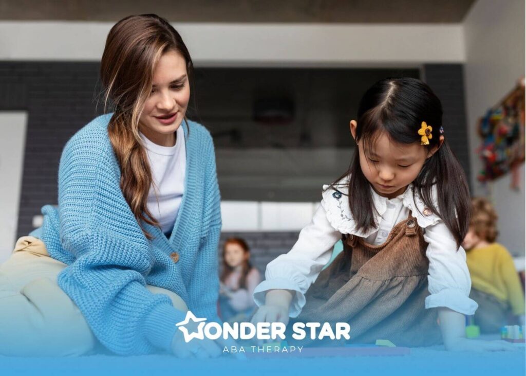 Therapist guiding an autistic girl during a hands-on learning activity on the floor in a structured ABA therapy.