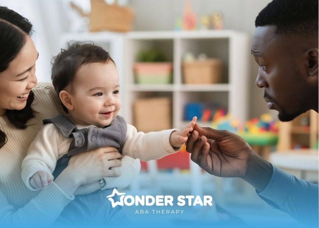 Therapist smiling as the autistic baby reaches toward a male therapist hand during a playful early intervention therapy.