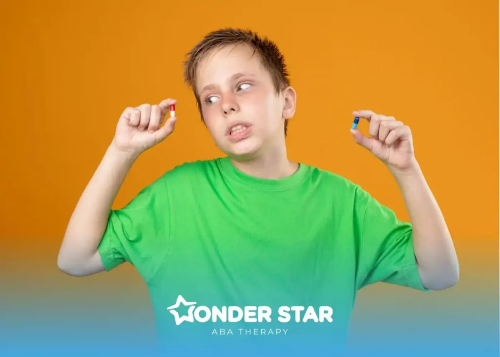 Autistic boy in green shirt holding two capsules against bright orange background, appearing unsure about medication choice.