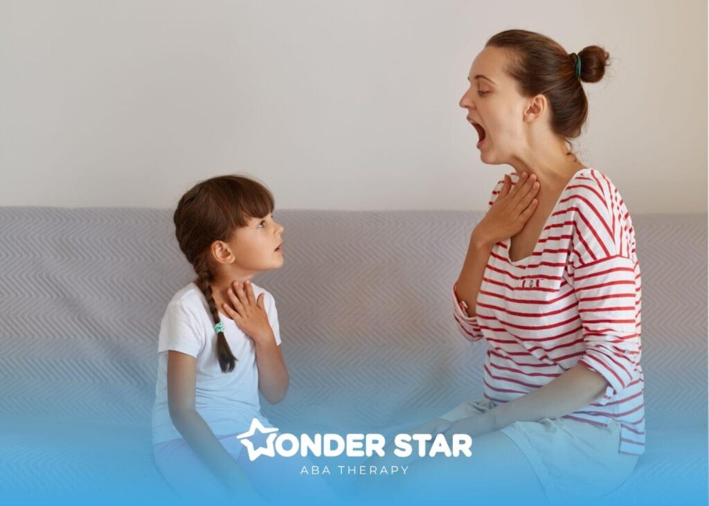ABA therapist and autistic girl practicing speech or pronunciation together while touching their throats during therapy.